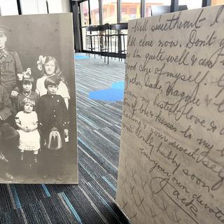 A picture of a solider and his family to the left, a copy of a letter in the foreground